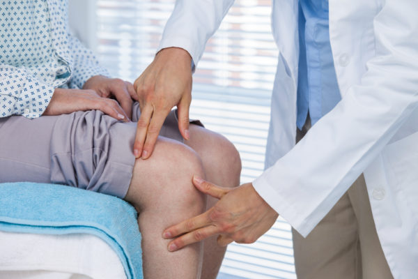 Doctor examining patient knee